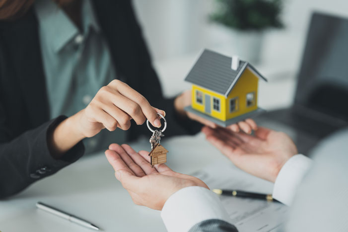 New homeowners receiving keys after completing their house purchase